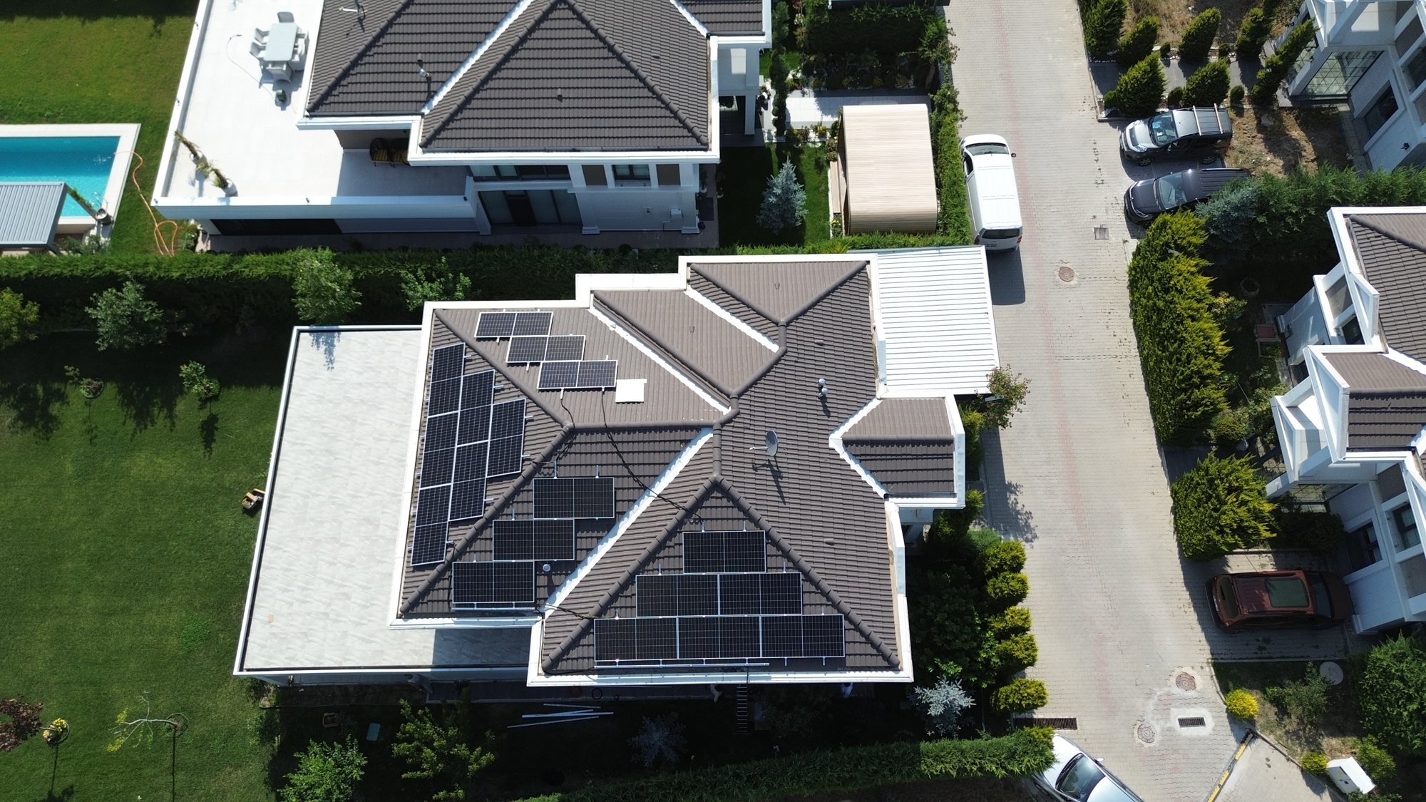 Villa çatısında kurulu güneş panelleri, bahçeli konut sitesinde drone görünümü